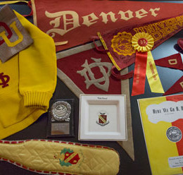 Many stations in "Tradition and Legacy" include cases full of artifacts — from vintage athletics and cheerleading uniforms to Commencement scepters and DU beanies.